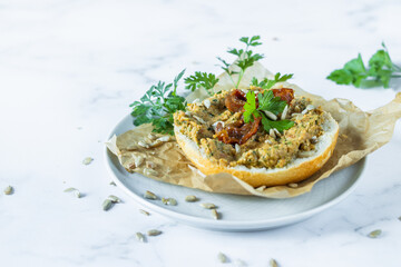 Sandwich with vegetable paste decorated with dried tomatoes and parsley