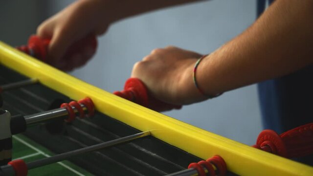 close up of kids playing the foosball table
