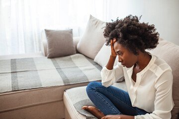 Young black woman suffering strong headache. Shot of a young woman experiencing a difficult moment. Shot of a young businesswoman looking stressed. 