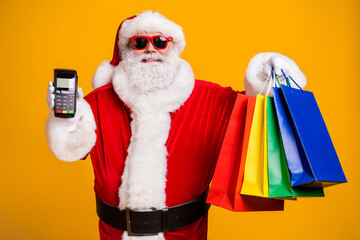 Portrait of his he nice attractive cheerful fat Santa holding in hands carrying things digital...