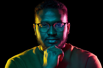 people and ethnicity concept - portrait of young african american man in glasses over black background