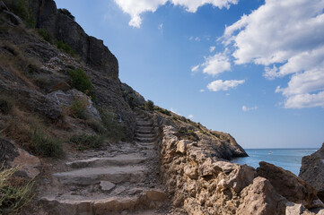stairs leading to the mountains, blue sky and sea