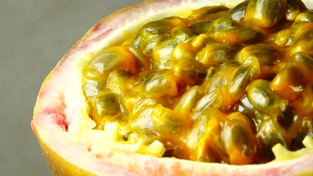 4K cross-section of a puple passion fruit Macro shot of sliced fresh exotic passion fruit fruit rotating 