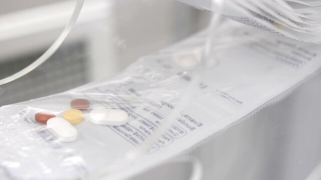 Roll of pre-packaged pills on production line, close up
