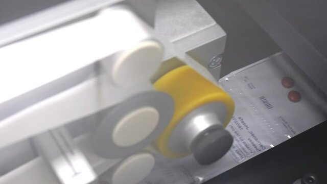 Packaged pills moving through production line, sliding reveal