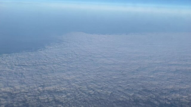 Extremely high bird's eye view, skyline, airplane flight, beautiful clouds, view from a porthole.