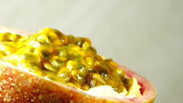 4K cross-section of a puple passion fruit Macro shot of sliced fresh exotic passion fruit fruit rotating 