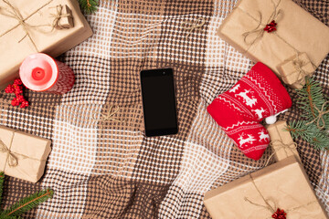 Christmas online shopping with phone. Online shopping concept - full Shopping Cart and gift box.screen of smartphone with copy space.