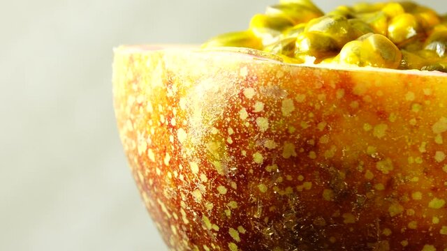 4K cross-section of a puple passion fruit Macro shot of sliced fresh exotic passion fruit fruit rotating 