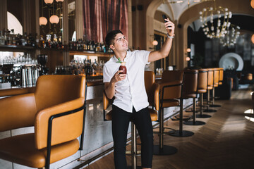 Student taking selfie at counter in empty bar