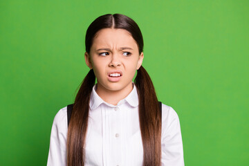 Photo of cute small lady in front of blackboard look empty space grimace arrogant a-student boring essay lesson stupid question wear uniform white shirt isolated green color background