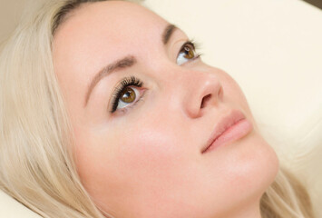 Eyelash Extension Procedure. Woman Eye with Long Blue Eyelashes. Close up, selective focus.