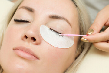 master lashmaker performs eyelash degreasing . Eyelash extension procedure. Microbrush