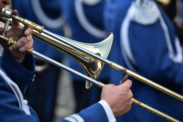 Military orchestra man performing during ceremony. Detail with musician hands playing on flute.