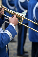 Military orchestra man performing during ceremony. Detail with musician hands playing on flute.