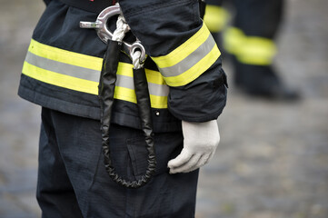 Fire fighters uniform detail with carabiner and harness during ceremony