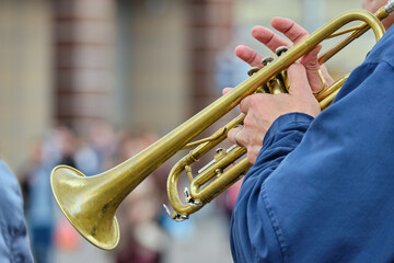 Person playing music on a trumpet in the street