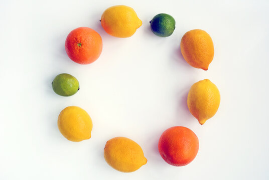 Oranges, lemons and lime lie in a circle on a white background