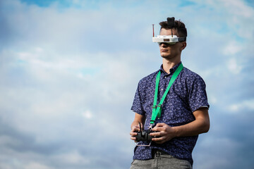 Man playing with the drone. He holds a remote control in his hand and has virtual glasses on his head.