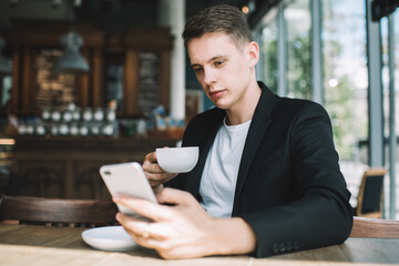 Young man using smartphone in cafe