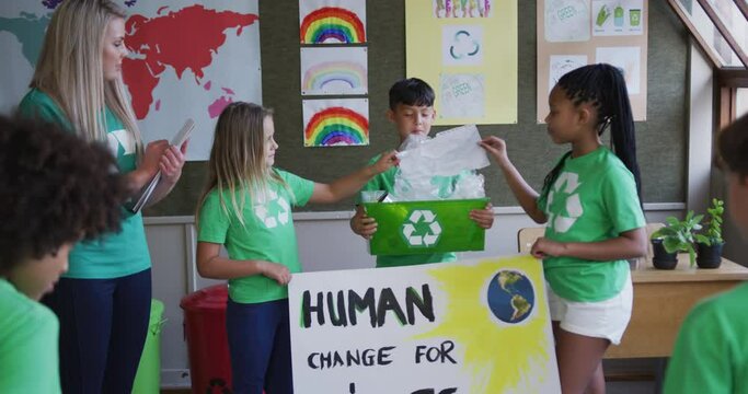 Group of kids holding climate change banner and recycle container at school