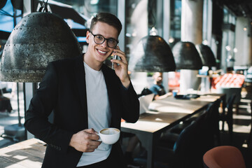 Smiling man talking on cellphone in cafe