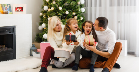 Happy family playing with Christmas gifts at home