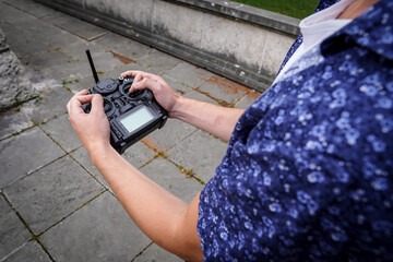 Young man is holding a drone remote controller in his hand.