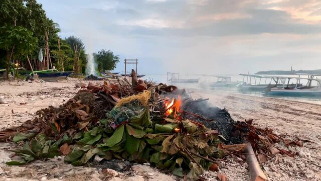 Burning Plastic Trash and dumped Garbage On beautiful beach on Gili Air Island.Save the planet.Static. shot.