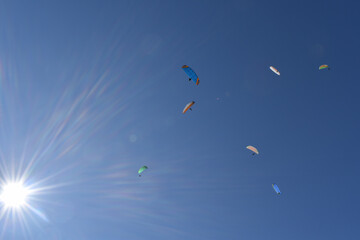 Kitegleiten im Himmel mit Sonne, grüne, gelbe und blauer Kite Fallschirme mit Gleitschirm Gleiter
