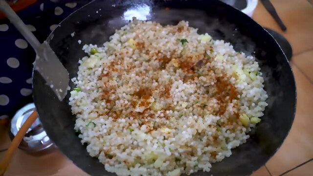 Sabudana Khichdi - Sago Polenta In A Pan Topped With Some Spices For Added Flavor And MIxed It With Flat Ladle. - close up top-down shot