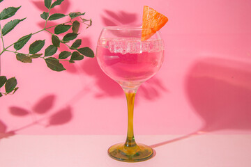 gin and tonic glass on pink background