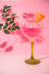 gin and tonic glass on pink background