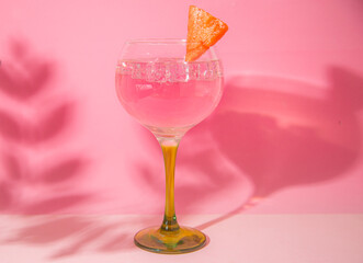 gin and tonic glass on pink background