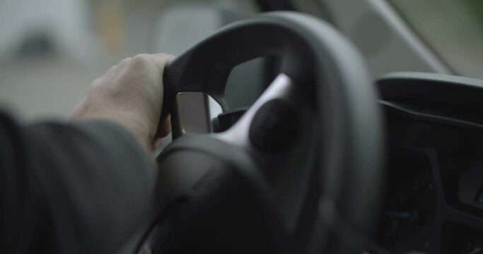 man steering a wheel while driving a car