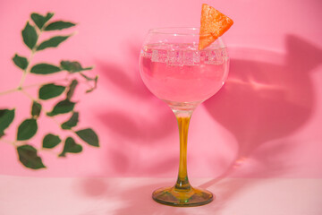 gin and tonic glass on pink background