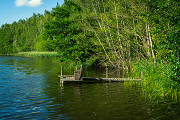 Fototapeta na wymiar Wooden fishing jetty on a small forest lake