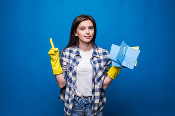 Young woman in apron with finger up isolated on blue background. Good idea to clean. Cleaning concept