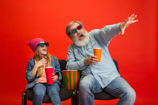 Shocked, Laughting. Senior Man Spending Happy Time With Granddaughter In Neon. Joyful Elderly Lifestyle, Family, Childhood, Tech Concept. Enjoying Modern Cinema, Movie Technologies. Copyspace.