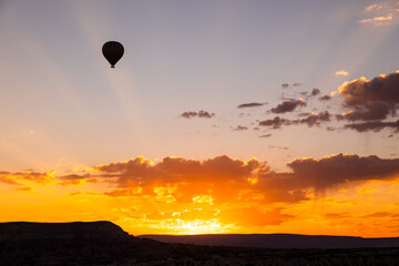 Hot air balloons flying over a volcanic landscape at Cappadocia, Turkey.