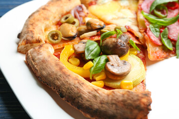 Slices of different pizzas on plate, closeup