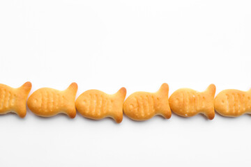 Delicious crispy goldfish crackers on white background, top view
