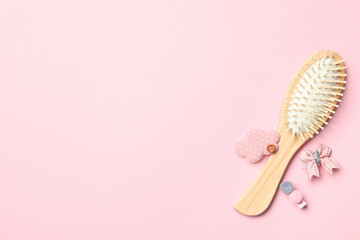 Flat lay composition with modern wooden hair brush on pink background. Space for text