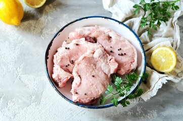 Raw fresh meat (pork) in bowl on gray background