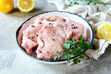 Raw fresh meat (pork) in bowl on gray background