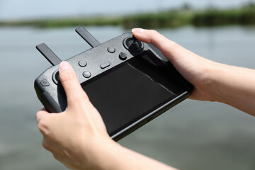 Woman with modern drone controller outdoors, closeup