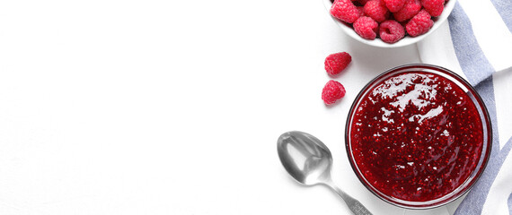 Delicious jam and fresh raspberries on white table, flat lay. Space for text