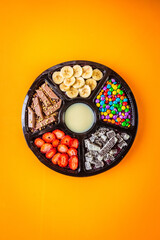 Acai frozen with banana, granola, chocolate and candies for share. A roulette for share.