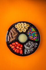 Acai frozen with banana, granola, chocolate and candies for share. A roulette for share.