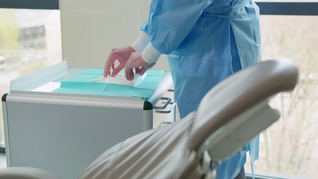 Dentist putting on surgical gloves in dentists office